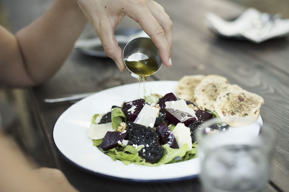 Black Seed Oil being poured onto a salad