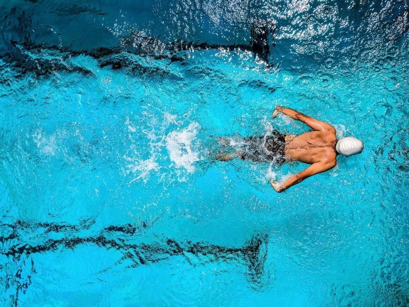 person swimming in a very blue pool