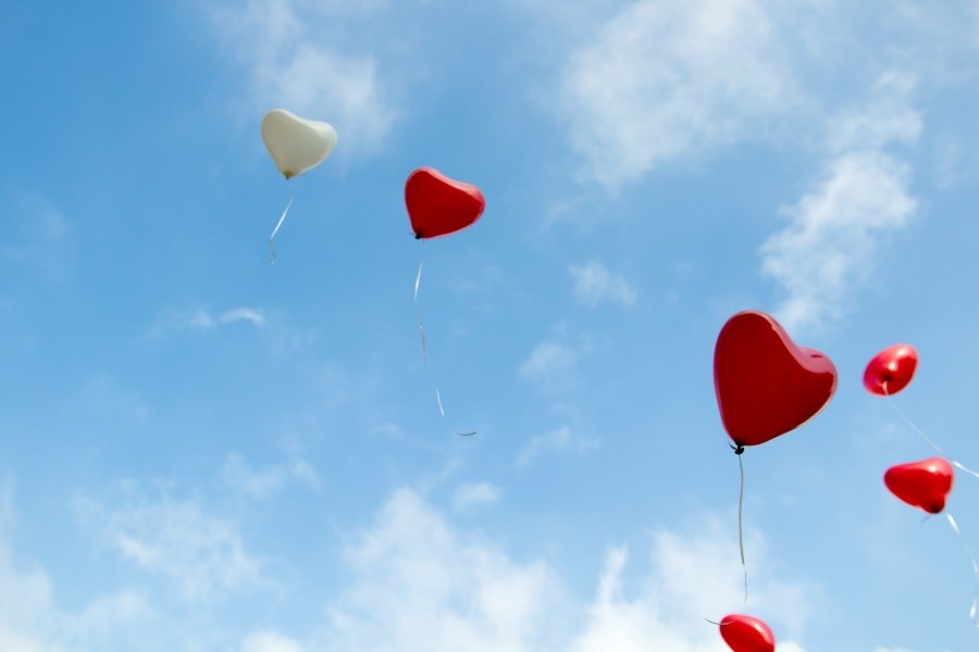 red heart balloons floating away