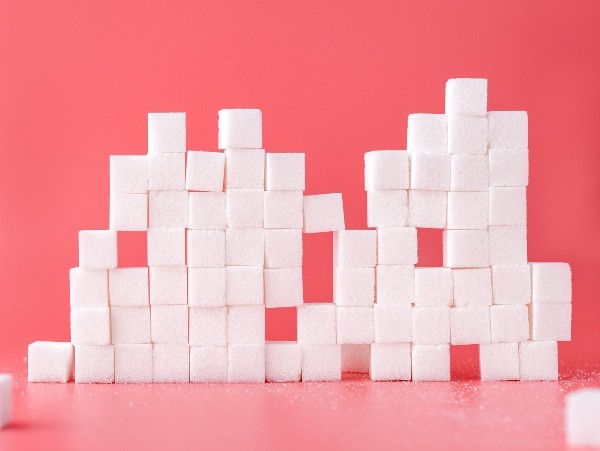 stacked white sugar cubes, with red background