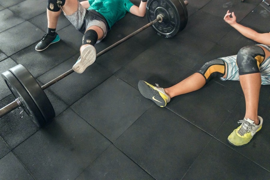 two people lying on ground tired after working out